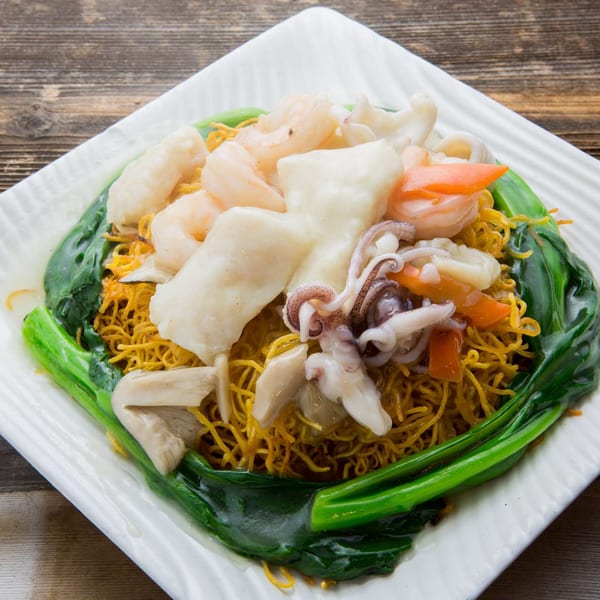 Delicious Food Corner's Chinese seafood chow mein with shrimp, squid, and green vegetables.